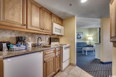 Kitchen with sink, light tile patterned floors, wh