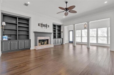 Spacious living room with built in bookcases and hardwood floors