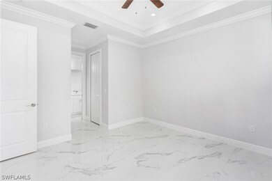 Spare room featuring a raised ceiling, ceiling fan