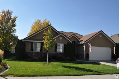 Single story home featuring stucco siding, a front lawn, and stone siding