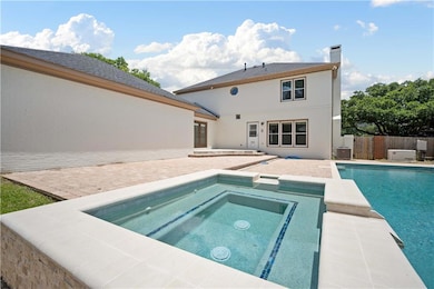 View of pool with an in-ground hot tub, a patio, and french doors