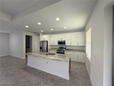 Kitchen featuring an island with sink, white cabin