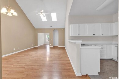 Kitchen featuring white cabinets, ceiling fan with