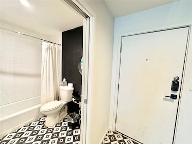 Bathroom with shower / bath combination with curtain and toilet
