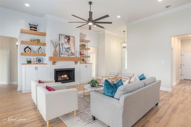Living room with crown molding, a fireplace, light