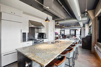 Kitchen features a large center island and Wolf ra