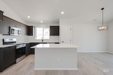 Kitchen featuring stainless steel appliances, a kitchen island, recessed lighting, light wood finished floors, and pendant lighting