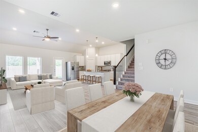 Alternate view of the lving area showing the view from the dining area showing the huge windows and door that accesses the backyard patio. Virtually staged