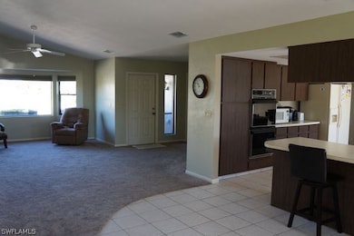 Family room with vaulted ceiling, foyer and open kitchen.
