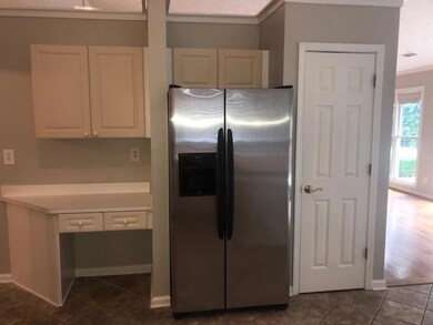 Kitchen with white cabinets, light countertops, ba