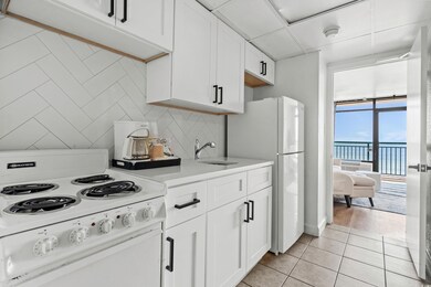 Kitchen featuring white cabinets, white electric r