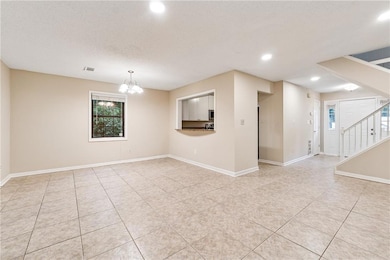 Unfurnished room with stairs, healthy amount of natural light, recessed lighting, a chandelier, and light tile patterned flooring