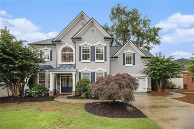 View of front of home featuring french doors, an attached garage, concrete driveway, stucco siding, and a standing seam roof