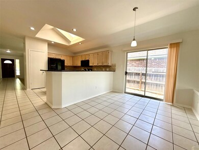 Kitchen featuring dark countertops, a skylight, l