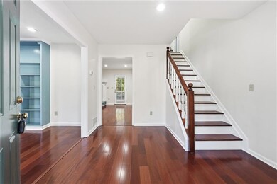 Foyer with dark wood-style floors, recessed lighting, and stairway