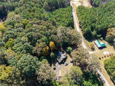 Aerial view of property and surrounding area with a forest