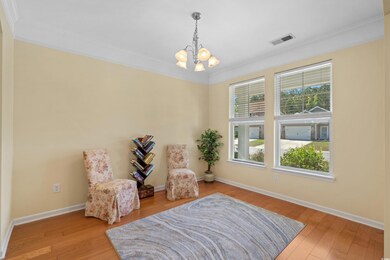 Sitting room with visible vents, crown molding, wo