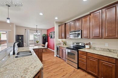 Kitchen with beverage cooler, a sink, light wood-s