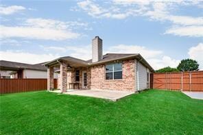 Rear view of property with a yard and a patio