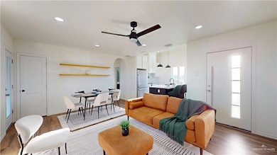 Living room with ceiling fan, recessed lighting, arched walkways, and wood finished floors