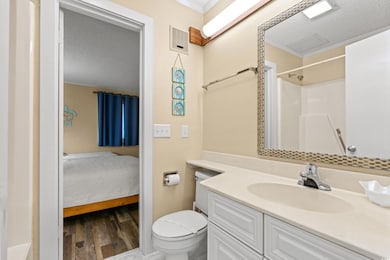 Ensuite bathroom with vanity, toilet, wood finished floors, a textured ceiling, and a shower