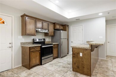 Kitchen featuring light stone countertops, a breakfast bar, and appliances with stainless steel finishes