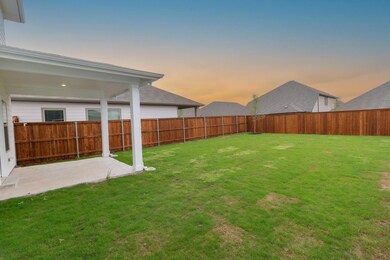 Yard at dusk featuring a fenced backyard and a pat