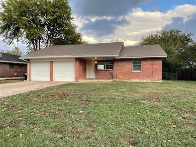 Single story home with a garage and a front yard
