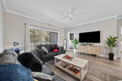 Living room with ornamental molding, wood finished floors, and ceiling fan