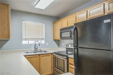 Kitchen with black appliances, light countertops,