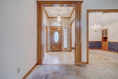 Tiled foyer entrance with a chandelier and crown m
