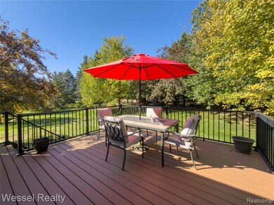 Wooden deck featuring outdoor dining area, a yard, and view of scattered trees