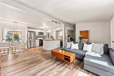 Living area featuring vaulted ceiling and light wood finished floors