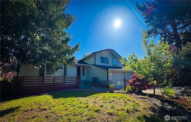 The house is nicely shaded, and the yard is landscaped. There is also a front porch/deck at the entrance.