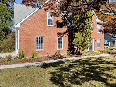 View of property exterior with a yard and brick siding
