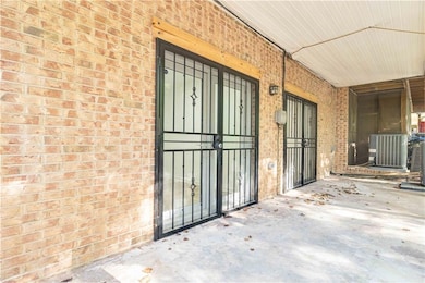 Doorway to property featuring brick siding and cen