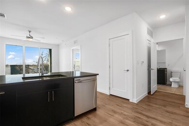 Kitchen with dark cabinetry, dishwasher, light wood finished floors, recessed lighting, and a ceiling fan