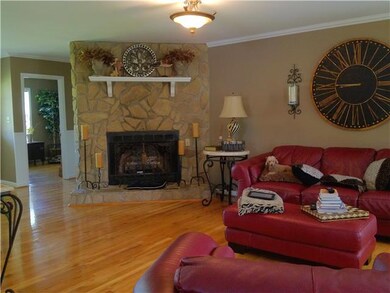 Living room with Hardwoods, Stone Fireplace and opens to Foyer and Dining room for entertaining