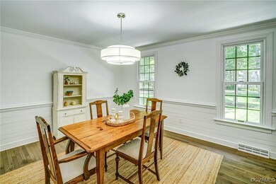 Hardwood floored dining space featuring crown mold