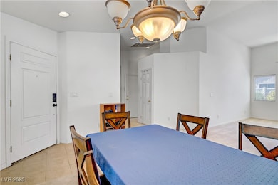 Dining room with a chandelier and light tile patte