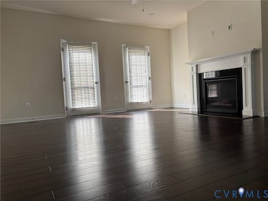 Unfurnished living room with a glass covered fireplace and hardwood / wood-style flooring