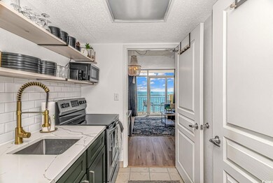 Kitchen with sink, light stone counters, stainless