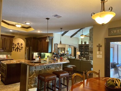 Great view of breakfast area off the kitchen which overlooks the living room. Very open floorplan. Door to outside covered patio, summer kitchen and pool area