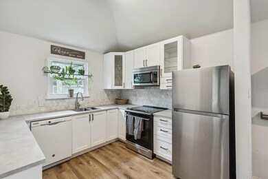 Kitchen featuring white cabinets, appliances with 