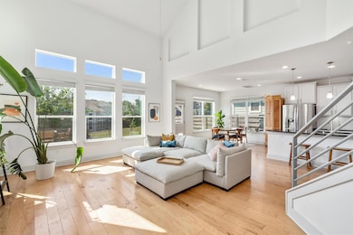 Living room with light wood-style flooring, a hig