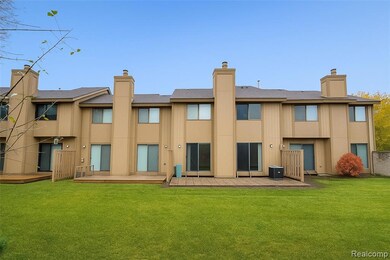 Rear view of house with a deck, a chimney, and a yard