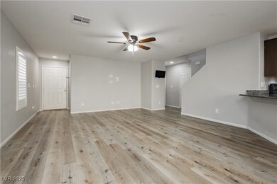 Unfurnished living room featuring ceiling fan and light wood-style floors
