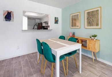 Dining room featuring wood tiled floors and baseb