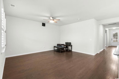 Unfurnished living room with dark wood finished floors and ceiling fan