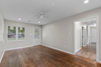 Unfurnished room with attic access, a ceiling fan, dark wood finished floors, and recessed lighting